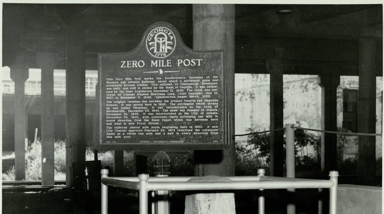 The Zero Mile Post is shown with a brand new historic marker in this photo from 1958. The landmark used to be exposed beneath a downtown viaduct and was open to the public. Today, it sits inslide a government building that remains locked. (AJC Archive at GSU Library / AJCP142-020I)
