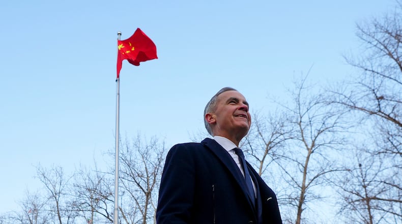 Prime Minister Mark Carney walks past a Chinese flag as he leaves after holding a press conference in Ritan Park in Beijing, China on Friday, Jan. 16, 2026. (Sean Kilpatrick /The Canadian Press via AP)