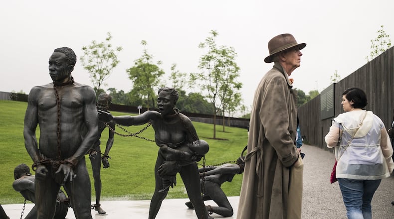 Steve Wing, 71, reads the signage near a sculpture commemorating the slave trade at the entrance of the National Memorial for Peace and Justice last year in Montgomery, Ala. The memorial is dedicated to the legacy of enslaved black people and those terrorized by lynching and Jim Crow segregation in America. Conceived by the Equal Justice Initiative, the memorial is intended to foster reflection on America’s history of racial inequality. BOB MILLER / GETTY IMAGES