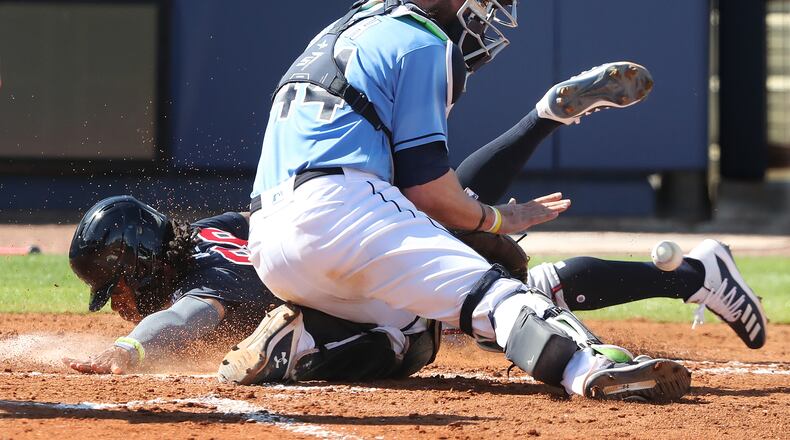 Atlanta Braves outfielder Justin Dean touches home plate past the tag of Tampa Bay Rays catcher Kevan Smith during the fourth inning of the spring training opening game Sunday, Feb. 28, 2021, at Charlotte Sports Park in Port Charlotte, Fla. (Curtis Compton / Curtis.Compton@ajc.com)