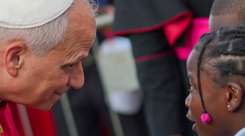 Pope Leo XIV listens to a girl as he arrives at the Parish of Our Lady of Fatima in Luanda, Angola, for a meeting with bishops, priests, consecrated men and women, and pastoral workers Monday, April 20, 2026, on the eighth day of an 11-day apostolic journey to Africa (AP Photo/Andrew Medichini)
