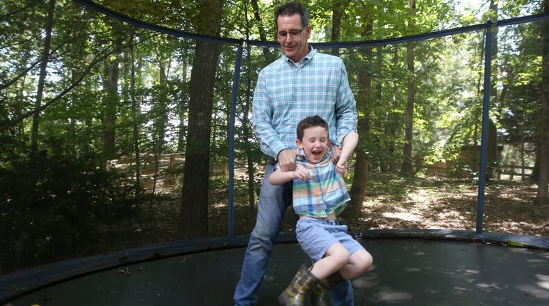 Mat Davis plays with his 5-year-old son, Joshua, on a trampoline in their backyard June 27, 2017, in Johns Creek. Joshua Davis has become an activist for his father, Mat, and others who have Alzheimer’s. The Davis family recently went to D.C. and talked with politicians about the cause. CONTRIBUTED BY JASON GETZ