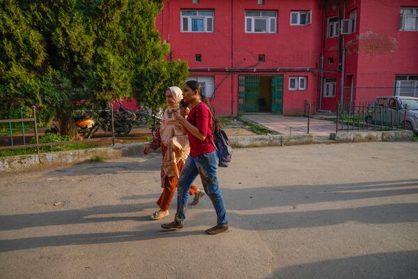 An Indian tourist, right, with blood-soaked trousers speaks on the phone as she arrives at a hospital in Anantnag after assailants indiscriminately fired at tourists visiting Pahalgam, Indian controlled Kashmir, Tuesday, April 22, 2025.(AP Photo/Dar Yasin)
