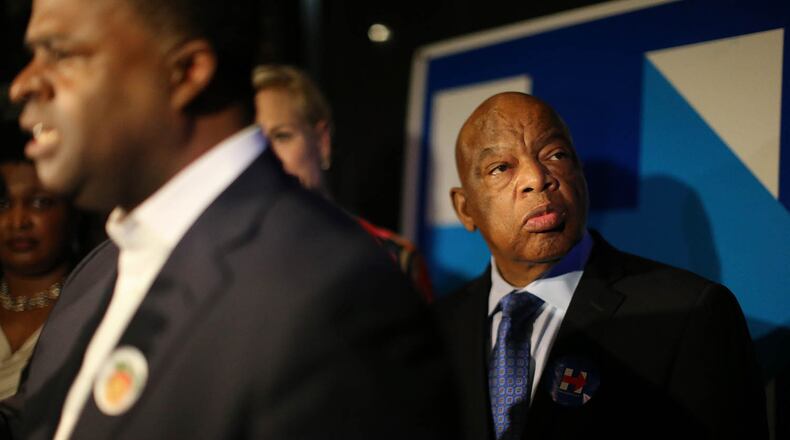 U.S. Rep. John Lewis watches primary returns roll in Tuesday evening March 1, 2016 as Atlanta Mayor Kasim Reed speaks to the crowd at a Hillary Clinton watch party at Paschal's Restaurant in Atlanta. Ben Gray / bgray@ajc.com