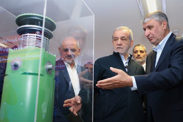 FILE - In this photo released by the Iranian Presidency Office, President Masoud Pezeshkian, second right, listens to Head of the Atomic Energy Organization of Iran Mohammad Eslami as he visits an exhibition of Iran's nuclear achievements in Tehran, Iran, April 9, 2025. (Iranian Presidency Office via AP)