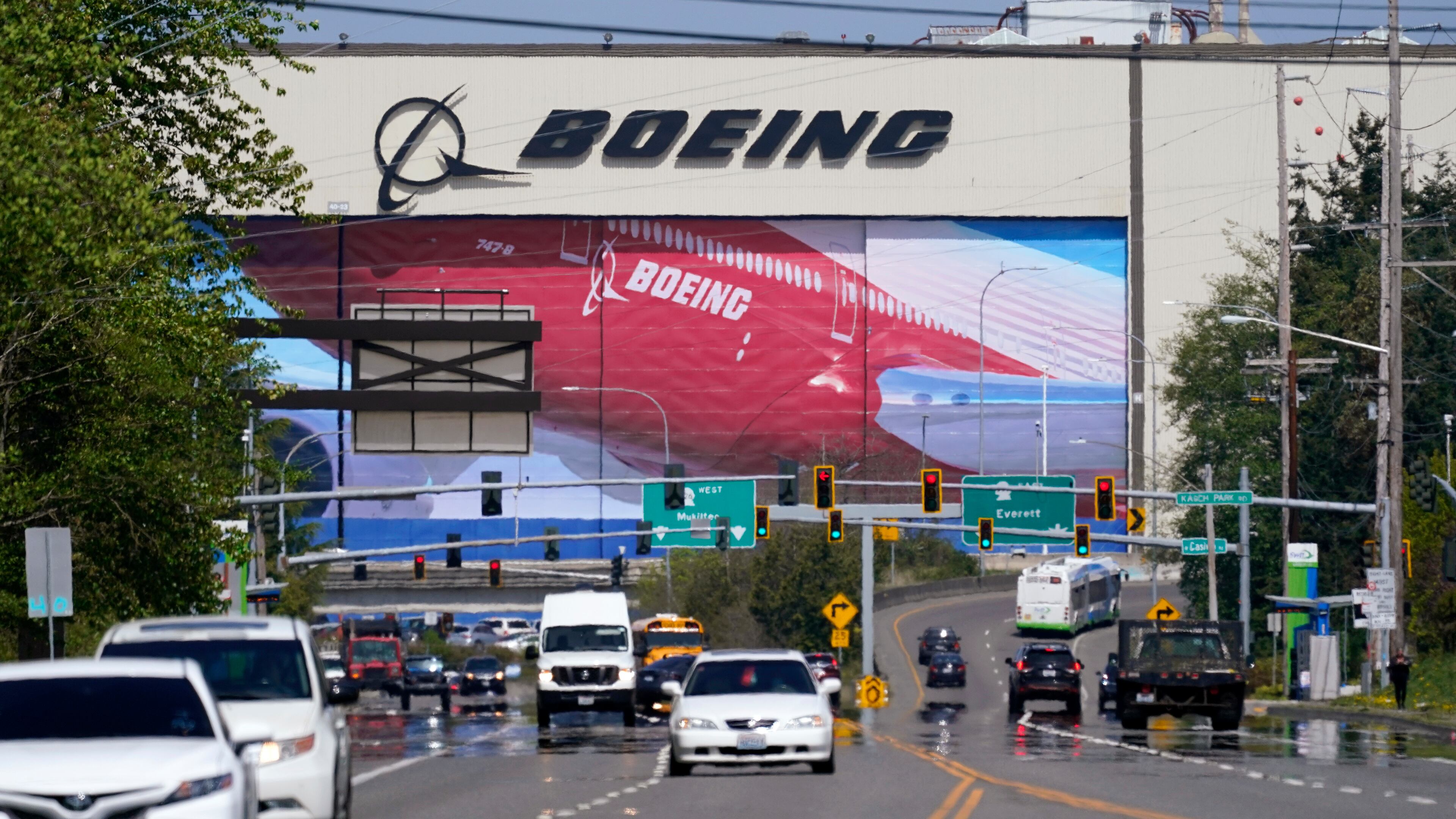 FILE - Traffic drives in view of a Boeing Co. production plant, where images of jets decorate the hangar doors on April 23, 2021, in Everett, Wash. (AP Photo/Elaine Thompson, File)
