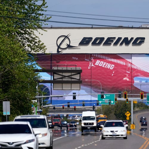 FILE - Traffic drives in view of a Boeing Co. production plant, where images of jets decorate the hangar doors on April 23, 2021, in Everett, Wash. (AP Photo/Elaine Thompson, File)