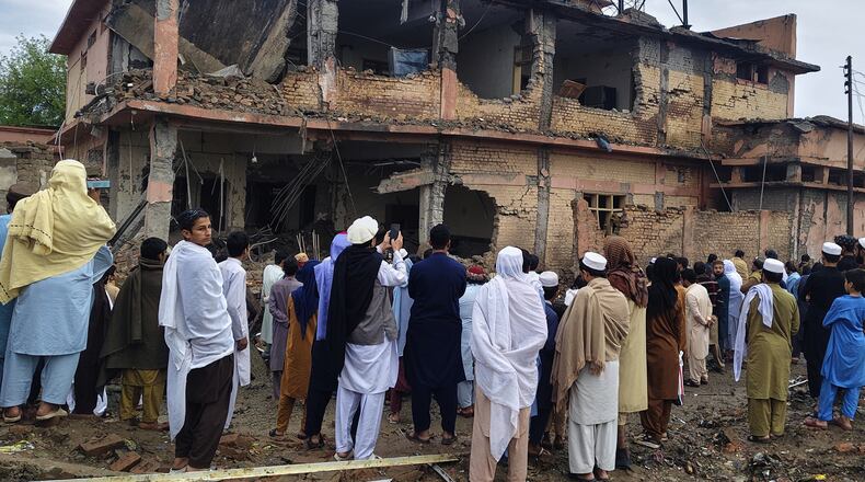 Local residents look at the damaged portion of a police station at the site of an overnight suicide bombing, in Bannu, a district of northwestern Pakistan, Friday, April 3, 2026. (AP Photo/Amaad Khattak)