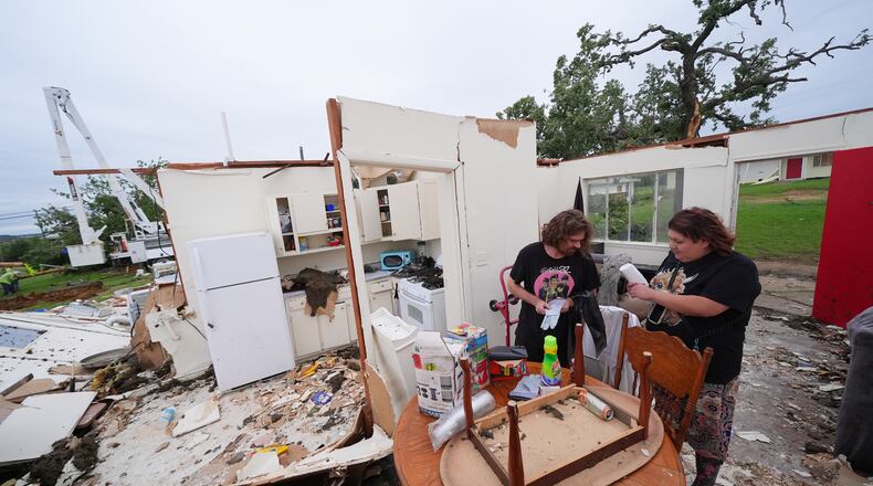 Christopher Hester, left center, talks to friend Brianna Corter, as he salvages belongings from his storm-damaged home in Mineral Wells, Texas, Wednesday, April 29, 2026. (AP Photo/Julio Cortez)