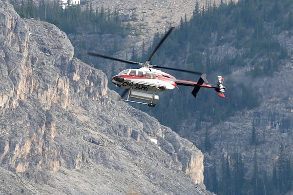 A helicopter is seen close to the scene of a rock slide near Bow Glacier Falls, north of Lake Louise, Alta. in Banff National Park on Thursday, June 19, 2025. (Larry MacDougal/The Canadian Press via AP)