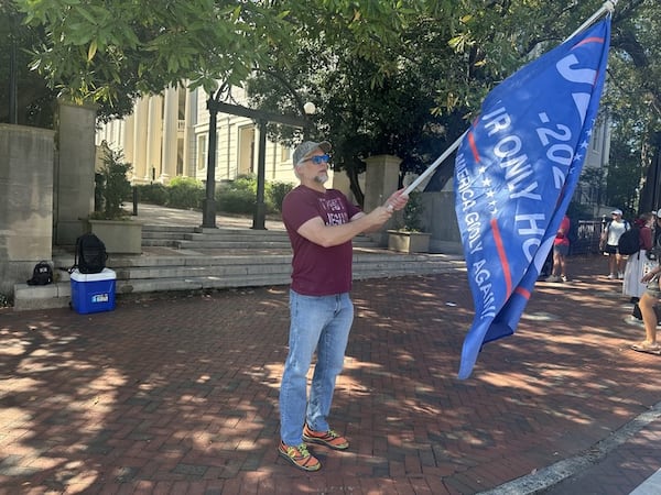 The shooting death of Charlie Kirk compelled Richard Suplita to come to The Arch on the University of Georgia campus in Athens on Thursday, Sept. 11, 2025. Suplita waved flags with Christian messages and spoke about his views to people walking toward campus and downtown. (Fletcher Page/AJC)