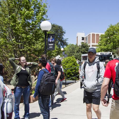 Students wait for buses at the Tate Student Center bus stop on the University of Georgia campus in Athens. (AJC file photo)