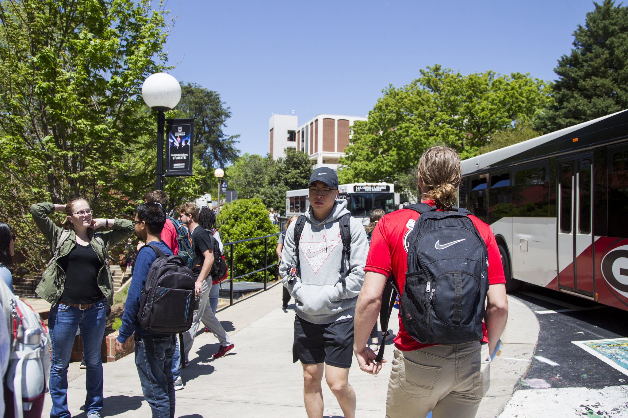 Students wait for buses at the Tate Student Center bus stop on the University of Georgia campus in Athens. (AJC file photo)