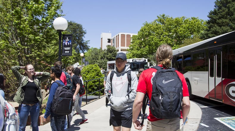 Students wait for buses at the Tate Student Center bus stop on the University of Georgia campus in Athens in this AJC file photo. This year, UGA produced a handbook for freshmen who were the first in their families to go to college, using simple and clear English. REANN HUBER / SPECIAL TO THE AJC