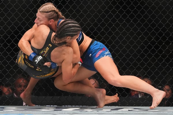 Kayla Harrison, right, grapples with with Julianna Peña during the first round of a women's bantamweight bout at the UFC 316 mixed martial arts event Sunday, June 8, 2025 in Newark, N.J. (AP Photo/Frank Franklin II)