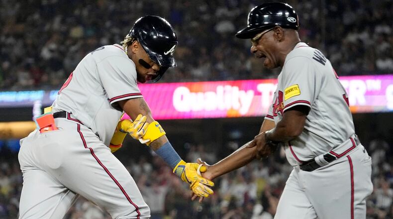Atlanta Braves' Ronald Acuna Jr., left, is congratulated by third base coach Ron Washington after hitting a grand slam during the second inning of a baseball game against the Los Angeles Dodgers Thursday, Aug. 31, 2023, in Los Angeles. (AP Photo/Mark J. Terrill)
