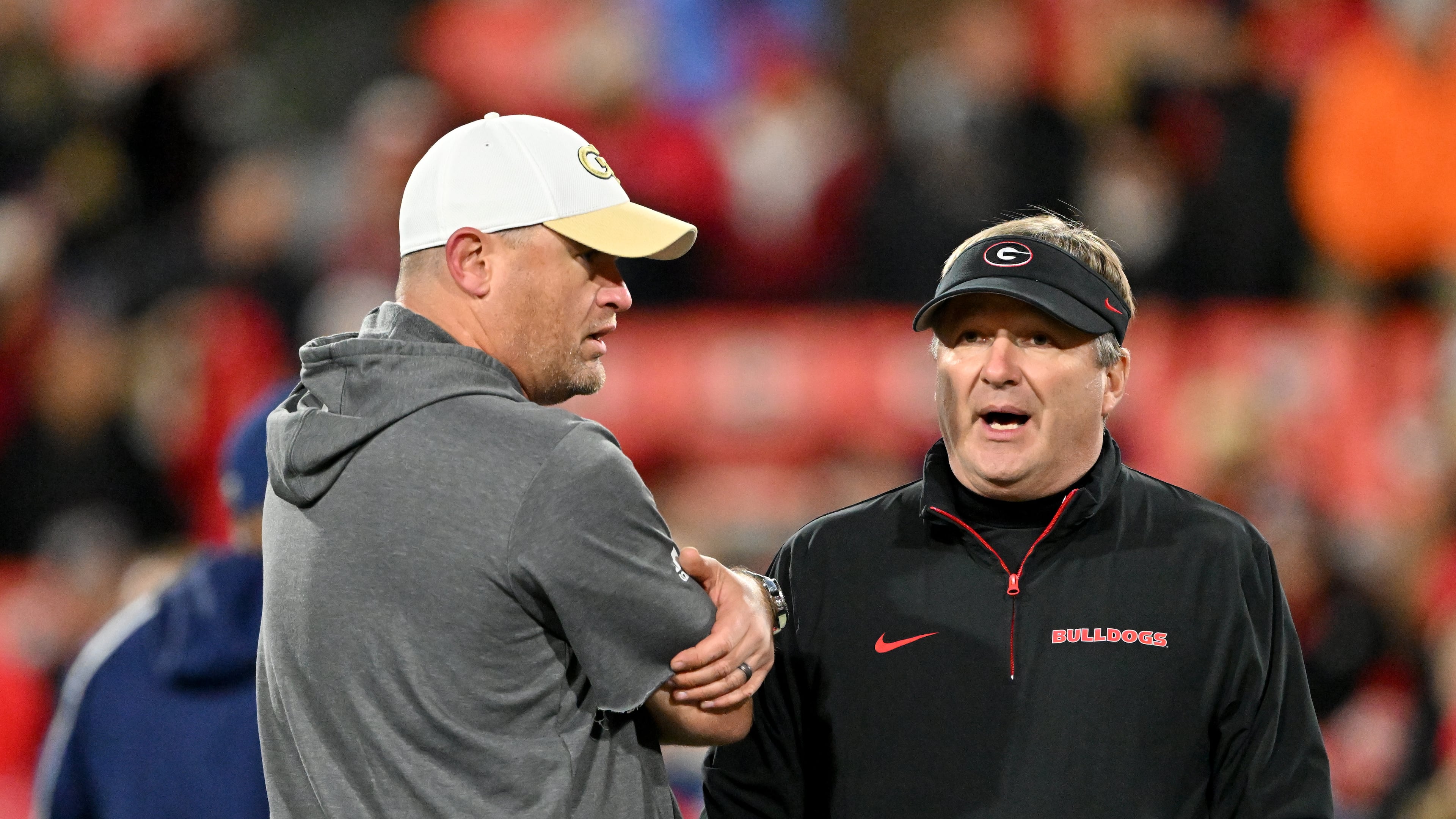 Georgia Tech's Brent Key (left) and Georgia's Kirby Smart — pictured chatting before the 2024 matchup between the teams — both still have a shot at making their conference title games. The Bulldogs need Texas A&M to lose to Texas or Alabama to lose to Auburn, and the Yellow Jackets need losses by Southern Methodist, Pitt and Virginia. (Hyosub Shin/AJC 2024)