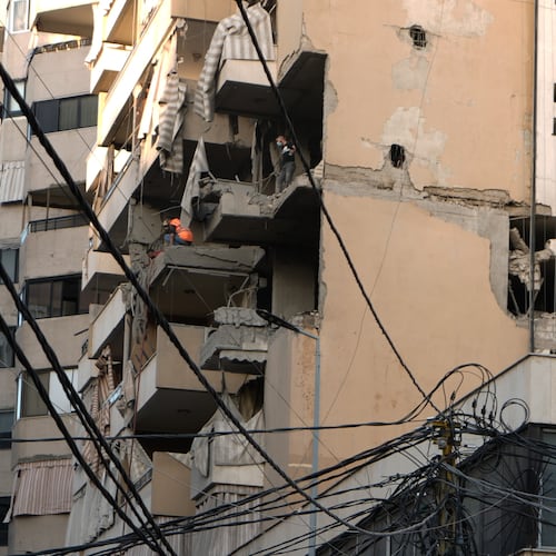 Civil Defence workers inspect the damage after an apartment was hit during an Israeli airstrike on Dahiyeh in the southern suburb of Beirut, Sunday Nov. 23, 2025. (AP Photo/Bilal Hussein)