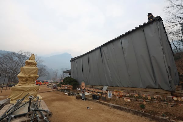 Buddhist temple and pagoda are covered by flameproof materials to prevent them from damage from wildfire at Daejeon temple in Cheongsong, South Korea, Thursday, March 27, 2025. (Kim Do-hun/Yonhap via AP)