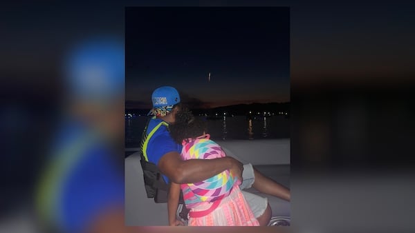 Reginald Wesley watches the fireworks with Tilly Roache on July Fourth on Lake Oconee. Tilly couldn’t swim, but she loved the water, her mother said. (Courtesy)