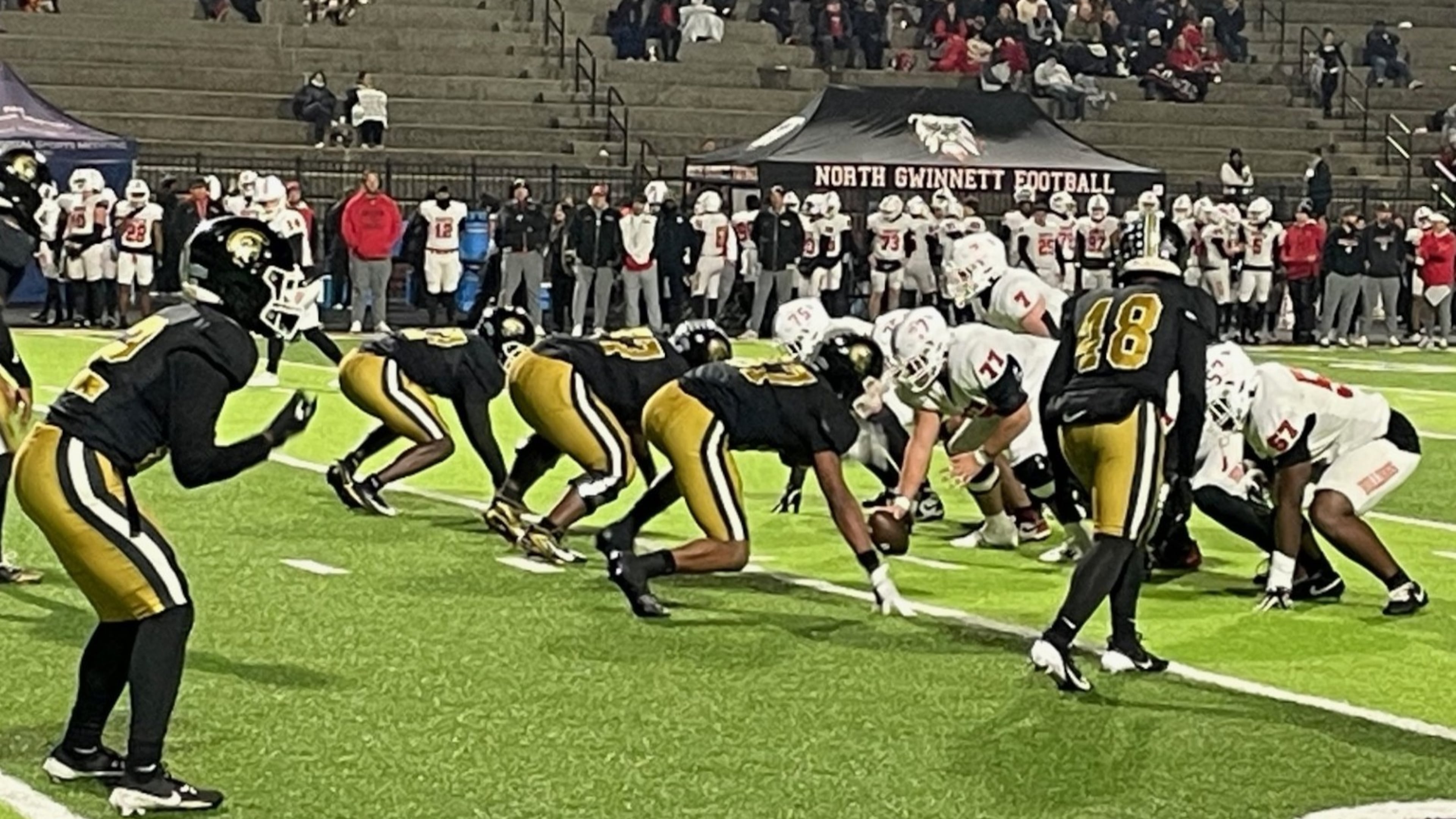 The Carrollton defense, lined up for a fourth-quarter play in the Class 6A semifinals, held North Gwinnett to 57 first-half yards in a 48-21 victory on Friday, Dec. 5, 2025, in Carrollton. (Chip Saye/AJC)