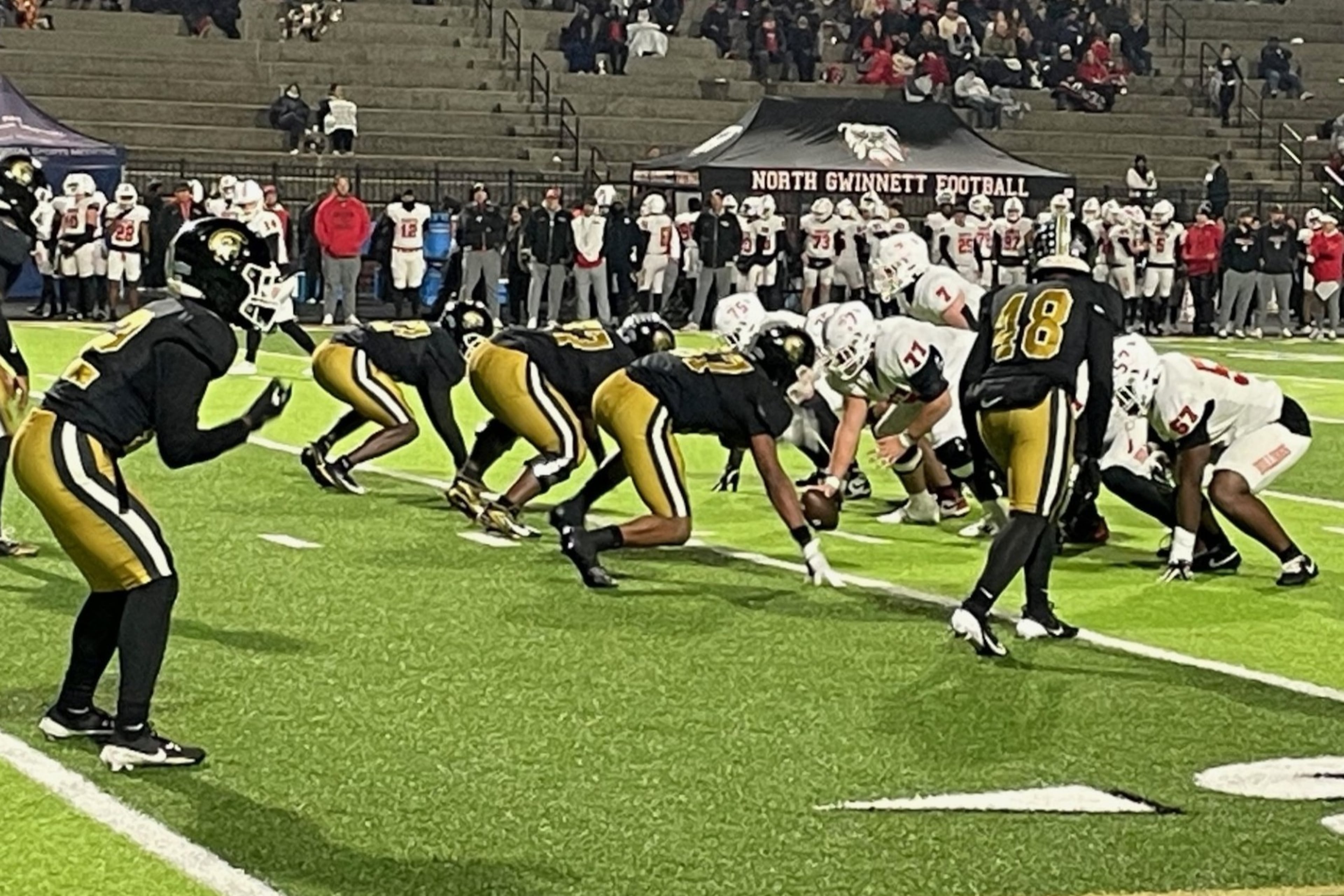 The Carrollton defense, lined up for a fourth-quarter play in the Class 6A semifinals, held North Gwinnett to 57 first-half yards in a 48-21 victory on Friday, Dec. 5, 2025, in Carrollton. (Chip Saye/AJC)