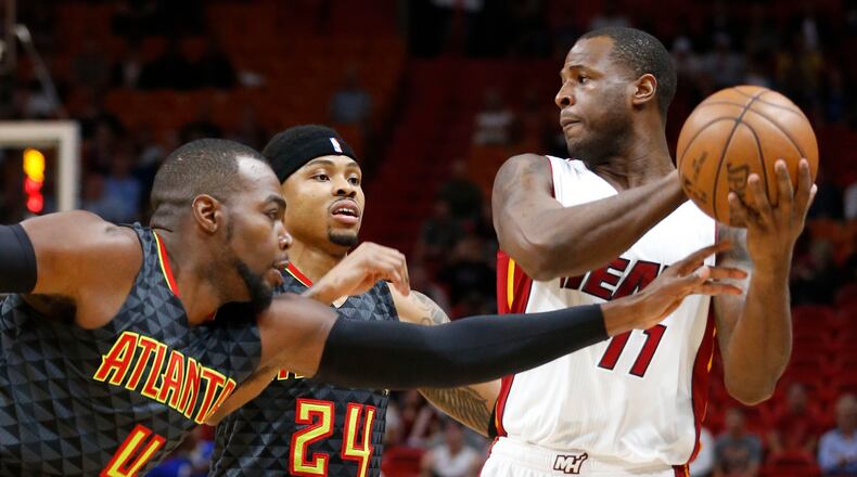 Miami Heat guard Dion Waiters (11) looks for an open teammate past Atlanta Hawks guard Kent Bazemore (24) and forward Paul Millsap (4) during the first half of an NBA basketball game, Wednesday, Feb. 1, 2017, in Miami. (AP Photo/Wilfredo Lee)