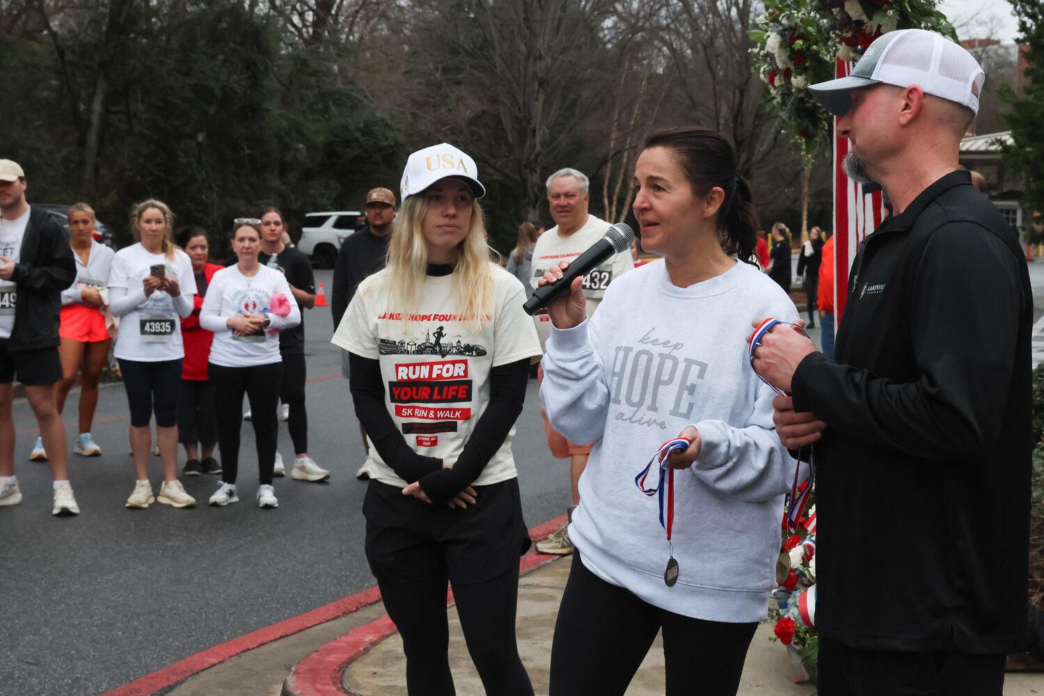 Allyson and John Phillips, Laken Riley’s mother and stepfather, speak on Saturday, Feb. 21, 2026, at a 5K walk/run and memorial service for their daughter on the UGA campus. Riley was attacked on Feb. 22, 2024 while running in Oconee Forest Park on the UGA campus and killed. Riley had previously attended UGA before transferring to Augusta University and was an avid runner.(C.J. Bartunek for the AJC)
