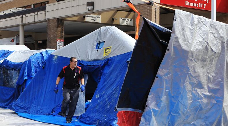 Workers set up tents in front of a hospital emergency room on March 27, 2020, in Marietta, which is among the medical centers treating coronavirus patients. (Christina Matacotta, for The Atlanta Journal-Constitution)