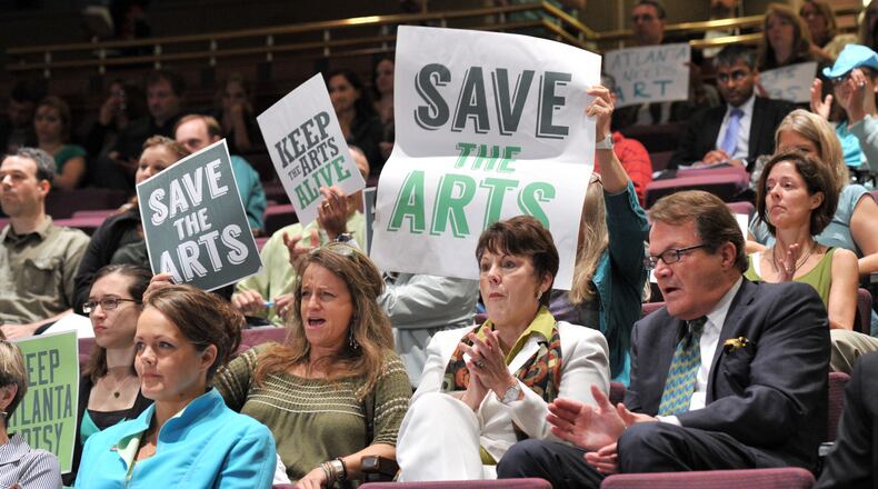 Supporters hold signs to support during public comment at Fulton County Board of Commissioners' Public Hearing at Fulton County Government Center on Wednesday.