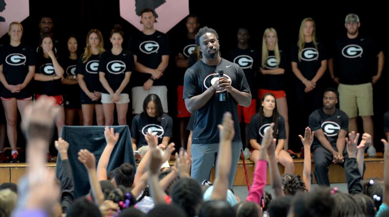 Former UGA football player Keith Marshall engages with students at D.H. Stanton Elementary School in 2015. The school is one of several that Atlanta Public Schools is planning to consolidate, causing some students to shift to new schools and job changes for staff. BRANT SANDERLIN/BSANDERLIN@AJC.COM