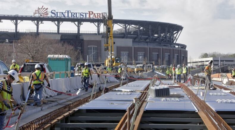 The elevated walkway over Windy Ridge Parkway to SunTrust Park is under construction and is one of the projects for which the Braves are seeking reimbursement from Cobb taxpayers. There is an on-going dispute between the county and Braves as to whether taxpayers are responsible for roads, bridges and other pedestrian improvements in and around the SunTrust Park development. BOB ANDRES /BANDRES@AJC.COM