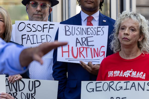 Supporters of Republican Derek Dooley, who is running for U.S. Senate, hold signs at a Dooley event outside incumbent Democrat Sen. Jon Ossoff’s office in Atlanta on Monday, Oct. 13, 2025, ratcheting pressure on the government shutdown. (Arvin Temkar/AJC)