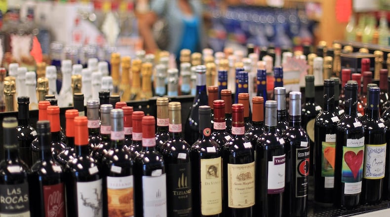 A customer walks by shelves full of red wine at Beverage City in Fairburn. JASON GETZ FOR THE AJC