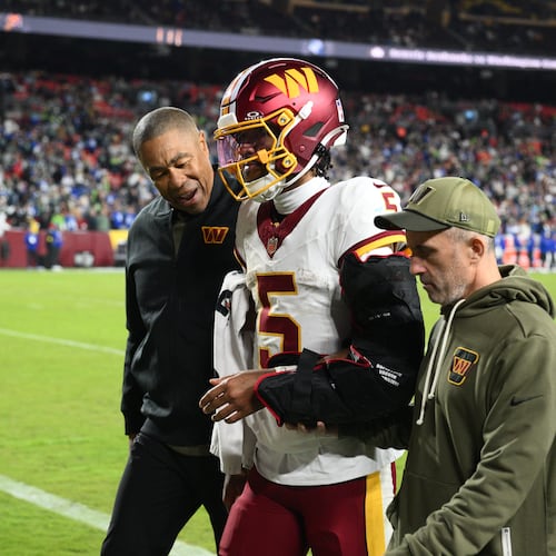 Washington Commanders quarterback Jayden Daniels (5) is helped off the field after he injuring his arm during a play in the second half of an NFL football game, Sunday, Nov. 2, 2025, in Landover, Md. (AP Photo/Nick Wass)