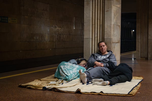 People rest in a metro station, being used as a bomb shelter, during a Russian drones attack in Kyiv, Ukraine, early Friday, June 6, 2025. (AP Photo/Dan Bashakov)