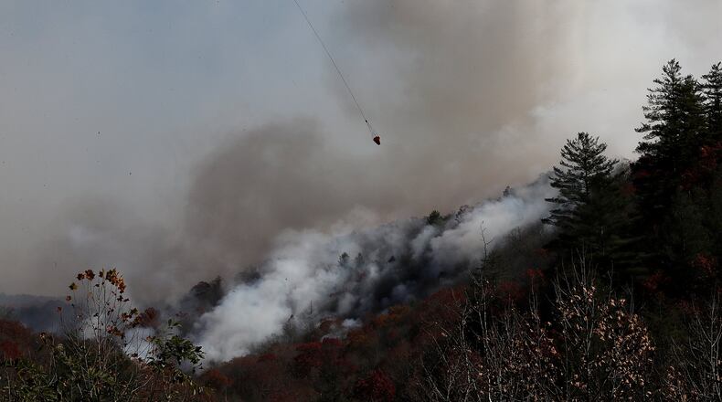A helicopter drops water on the Rock Mountain fire as it approaches homes on Wednesday, Nov. 16, 2016, in Tate City. (Curtis Compton/ccompton@ajc.com)