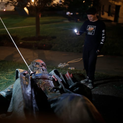 People film a statue of Confederate Gen. Albert Pike after it was toppled by protesters and set on fire in Washington early June 20, 2020. (Maya Alleruzz/AP)
