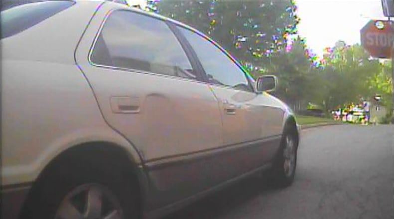 Video showing a car narrowly missing a student near their bus with its stop arm down. Footage courtesy of the Cobb County Police Department.
