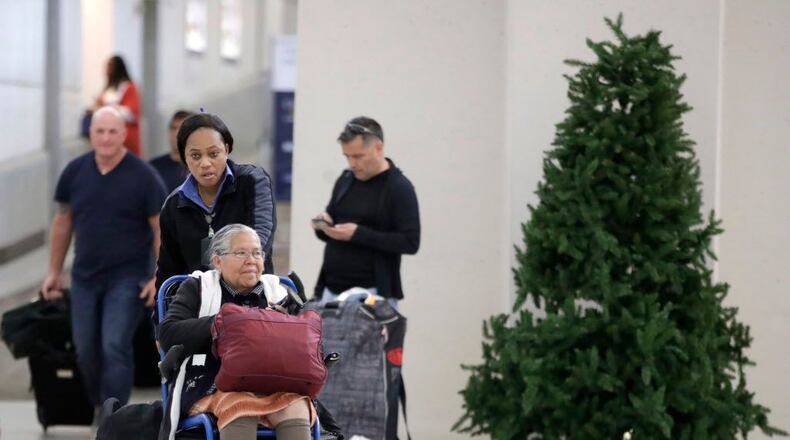 An employee pushes a woman on a wheelchair out of the international arrivals area on Terminal B at Newark Liberty International Airport on Nov. 21, 2017, in Newark, N.J.