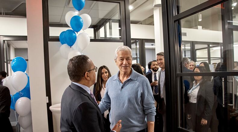 FILE - Jamie Dimon, CEO and chairman of JPMorgan Chase, center right, talks with an attendee during the community branch opening in the Bronx borough of New York, April 26, 2024. (AP Photo/Andres Kudacki, File)