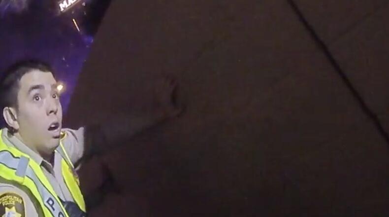 This still image captured by a Las Vegas officer's body camera shows a fellow officer crouching behind a wall during Sunday's shooting spree. Image: Las Vegas Metropolitan Police Department