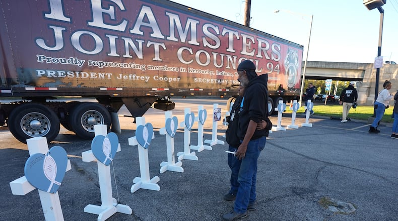 Allen Wilson, right, stands with an attendee after they wrote on crosses for victims during a vigil Thursday, Nov. 6, 2025, in Louisville, Ky., after a UPS plane crashed at Louisville Muhammad Ali International Airport. (Darron Cummings/AP)