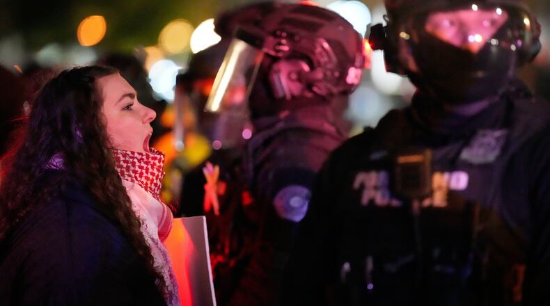A protester yells at a Portland police officer outside the U.S. Immigration and Customs Enforcement facility on Thursday, Jan. 8, 2026, in Portland, Ore. (AP Photo/Jenny Kane)