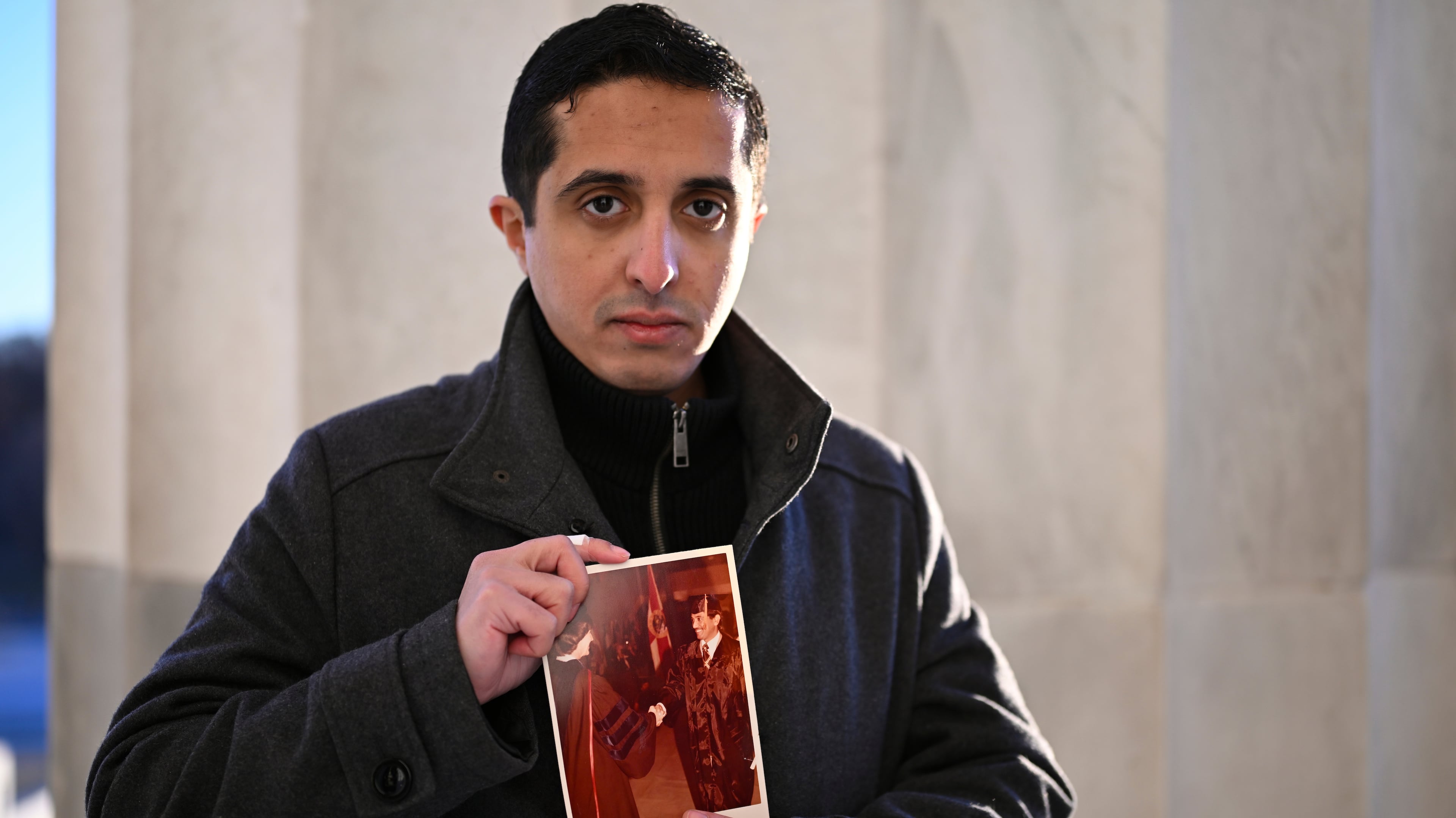 FILE - Ibrahim Almadi holds a photo of his father Saad Almadi graduating from college in 1984, in Washington, Dec. 23, 2024. (AP Photo/John McDonnell, File)