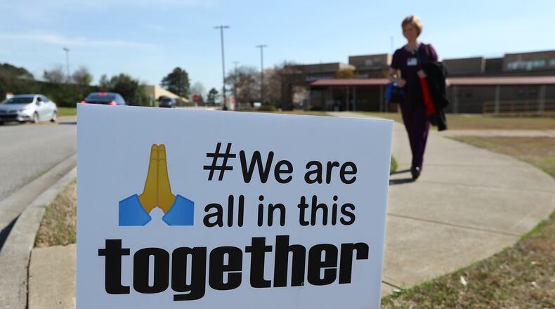 A nurse passes by a sign while leaving the Cartersville Medical Center, where many patients have been confirmed to have COVID-19 and several from the local community have died. Photographed on March 26, 2020.    Curtis Compton/ccompton@ajc.com