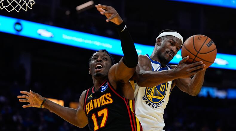 Golden State Warriors forward Jimmy Butler III (10) rebounds the ball next to Atlanta Hawks forward Onyeka Okongwu (17) during the first half of an NBA basketball game, Sunday, Jan. 11, 2026, in San Francisco. (AP Photo/Godofredo A. Vásquez)