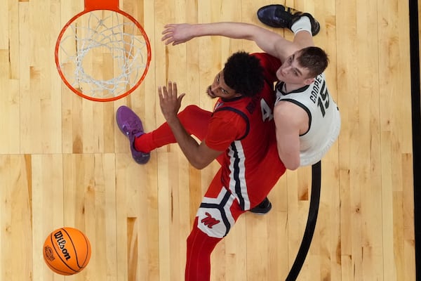 Mississippi forward Jaemyn Brakefield (4) and Michigan State center Carson Cooper (15) vie for a loose ball during the first half in the Sweet 16 of the NCAA college basketball tournament, Friday, March 28, 2025, in Atlanta. (AP Photo/George Walker IV)