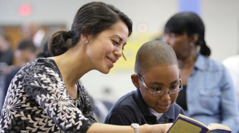 READING MENTOR--Monica Skidmore reads with Cook Elementary School student Joshua Campbell, 9, Thursday Jan. 19, 2012. She has been volunteering with the "Everybody Wins" program for five years and reading with Joshua for two years. They are reading an Animorphs book. Georgia First Lady Sandra Deal visited the "Power Lunch" program at Cook Elementary School in Atlanta. Volunteers are adult mentors who commit to weekly one-on-one reading sessions with a child during the lunch hour.