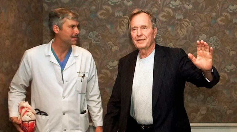 Former President George H.W. Bush waves with his cardiologist, Mark Hausknecht, after a news conference in Houston in 2000. Hausknecht was shot and killed by a fellow bicyclist Friday, July 20, 2018, while riding through a Houston medical complex.